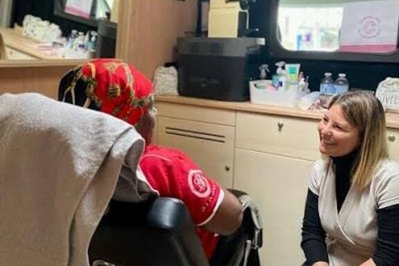 Une femme accueillie par Camping-Care discute avec une membre de l'association