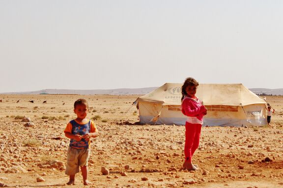 Enfants syriens devant une des tentes distribuées par le HCR pour les familles de réfugiés.