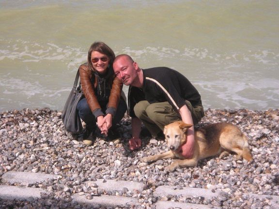 Une bénévole et un bénéficiaire qui pose au bord de la mer